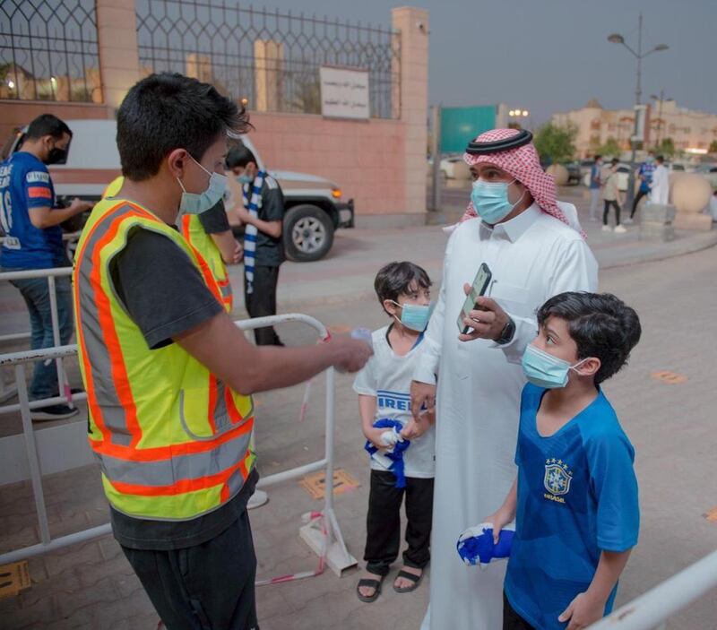 A man and two children enter the Prince Faisal bin Fahad stadium in Riyadh. SPA