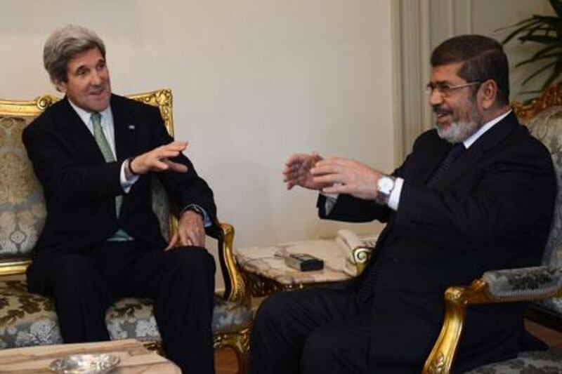 John Kerry, the US secretary of state, left, meets Egypt's president, Mohammed Morsi, at the presidential palace in Cairo on Sunday. Khaled Desouki / AFP