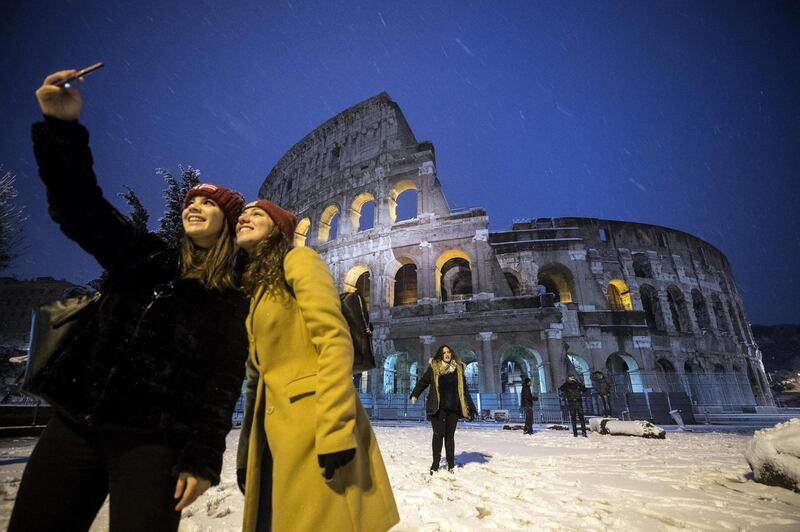 Tourists take a selfie in front of the Colosseum covered by snow during a snowfall in Rome, Italy. Angelo Carconi / EPA