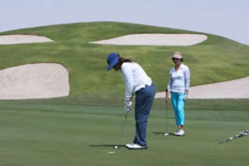 A panoramic view of the green on the fourth hole of the Montgomerie Golf club with the sprinkling of bunkers behind it.