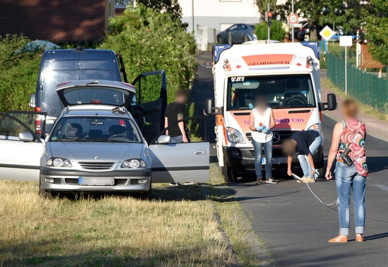 Picture taken on July 22, 2019 shows policemen securing evidences close to an ambulance car and a passenger car in Biebergemuend near Bad Orb, western Germany, where a German man, the suspected aggressor, was found dead in a car, following a drive-by shooting in the nearby village of Waechtersbach. Police were investigating on July 23, 2019 if the drive-by shooting of a 26-year-old man from Eritrea in a small west German town was racially motivated. The East African victim was left seriously wounded after being shot in Waechtersbach, near Frankfurt, after being fired at from a vehicle on Monday afternoon, July 22, 2019. While searching for the perpetrator, police said they later found a dead 55-year-old German man in a vehicle in a neighbouring town. - Germany OUT
 / AFP / DPA / OsthessenNews / Moritz PAPPERT
