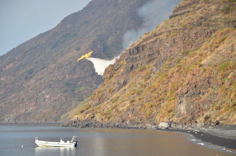 A Canadair plane drops water after the Stromboli volcano eruption started forest fires, in Stromboli, Italy.  Reuters