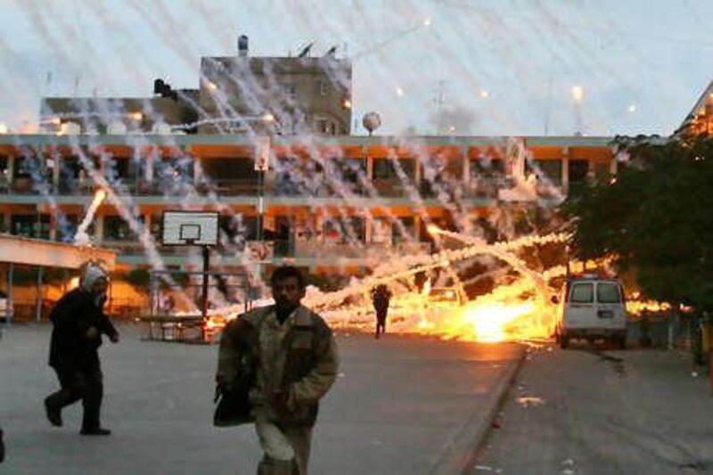 (FILES) -- A picture dated January 17, 2009 shows Palestinian civilians and medics runing to safety during an Israeli strike over a UN school in Beit Lahia, northern Gaza Strip. Israel will restrict its use of white phosphorus munitions and seek to limit civilian casualties in future wars, it said in a report to the UN secretary general released in July 2010. AFP PHOTO / MOHAMMED ABED