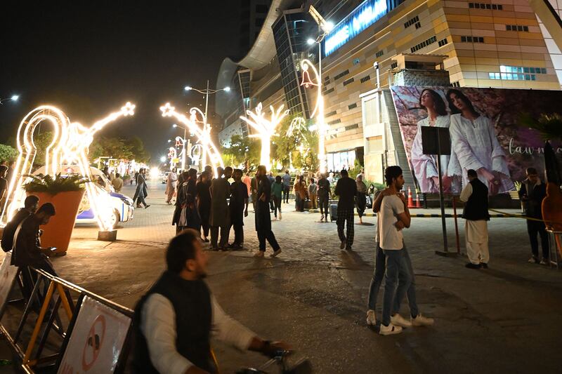 People gather outside a mall in Islamabad after the earthquake, which was felt in Pakistan, Afghanistan and parts of India. AFP
