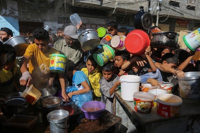 Palestinians crowd together as they wait for food distribution in Rafah, southern Gaza Strip. AP 