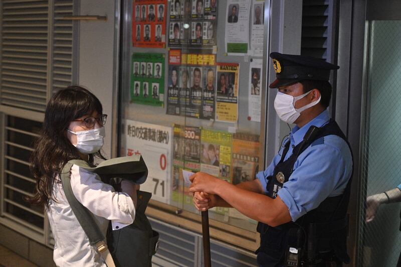 Tomoko Uraki, member of Japan lawyers network for refugees is stopped by a police officer outside the police station that Krystsina Tsimanouskaya is believed to be inside at Haneda airport in Toko.