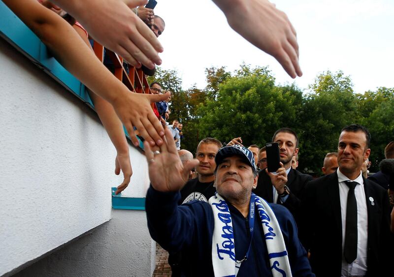 Diego Maradona is greeted by Dynamo Brest fans. Reuters