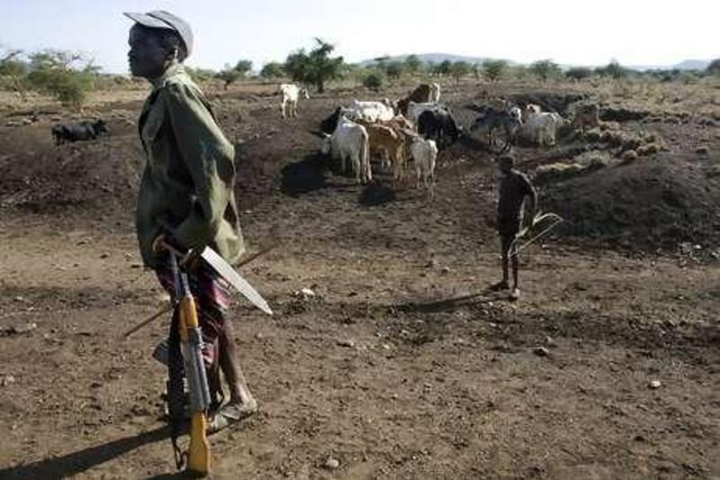 Armed with an AK-47 and a long knife, a Pokot herder guards his cattle in Northern Kenya, where ribal tribes are fighting over grazing land.