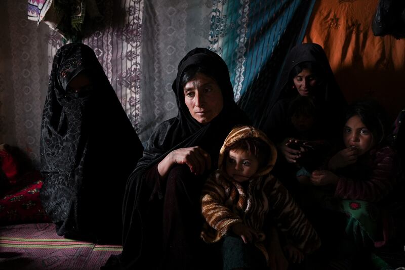 Guldasta and members of her family in their house at a settlement near Qala-e-Naw, Afghanistan.  Guldasta says that after days with nothing to eat, she told her husband to take their son Salahuddin, 8, to the bazaar and sell him to buy food for the others. AP Photo