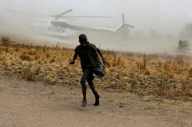 A boy moves away as a United Nations World Food Programme (WFP) helicopter lands in Rubkuai village, Unity State, northern South Sudan, February 18, 2017. Siegfried Modola: "I took this picture in the remote village of Rubkuai in South Sudan. The village is controlled by government forces. I had been in the area for several days, photographing people affected by insecurity and a food crisis days after the government and the international community declared a famine. It had been long day's work. I was trying to show the scale of the crisis and suffering. But I also wanted to capture moments of joy and playfulness to help the audience relate to the images and feel their urgency. I have never worked in a place as difficult as South Sudan. Access is extremely hard due to government restrictions, insecurity and the sheer remoteness of many locations. The village had been cut off from food supplies for months and thousands were threatened with famine. I spotted the arriving helicopter from a distance. It had come to help with a U.N. food distribution and I knew it would be swamped by children. I had my camera ready, looking for a picture of the helicopter and the village. Just then, a child ran past trying to escape the dust from the propellers. I clicked, hoping I had measured the light correctly and kept the boy in focus. I am fond of this image as it was taken unexpectedly, capturing a playful moment in an otherwise difficult situation." REUTERS/Siegfried Modola/File photo  SEARCH "POY STORY" FOR THIS STORY. SEARCH "REUTERS POY" FOR ALL BEST OF 2017 PACKAGES. TPX IMAGES OF THE DAY.