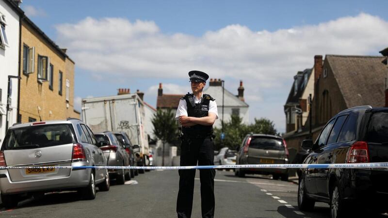 A police officer stands guard in the street where a heavily pregnant woman was stabbed to death in south London. Reuters