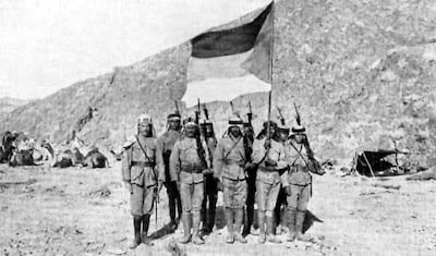 Arab soldiers carry the flag of the Arab Revolt of 1916-1918 in the Arabian desert.