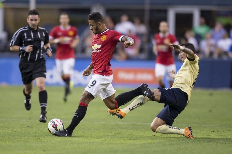 Manchester United's Memphis Depay goes to play the ball as he's tackled by Club America's Rubens Sambueza in their friendly match on Friday in the US. Stephen Brashear / AFP