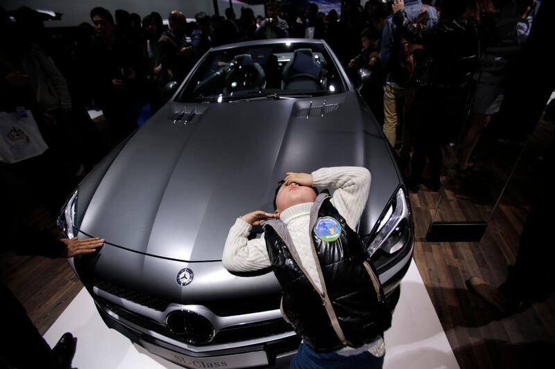 A young visitor leans against a Mercedes-Benz SL350 at the Shanghai International Automobile Industry Exhibition (AUTO Shanghai) in Shanghai, China Sunday, April 21, 2013. (AP Photo/Eugene Hoshiko) *** Local Caption ***  China Auto Show.JPEG-0332f.jpg