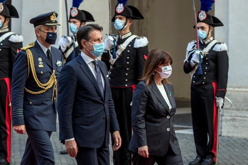 Greek President Katerina Sakellaropoulou, right, and Italian Premier Giuseppe Conte, both wearing masks to prevent the spread of Covid-19, review the honor guard prior to their meeting in Rome.  AP