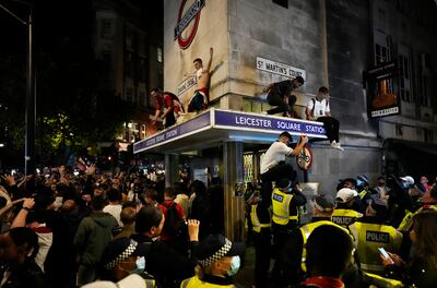 England fans celebrate as they stand on the roof of Leicester Square underground station after England's win against Denmark. AP Photo