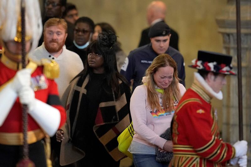 Members of the public pay their respects as they pass the coffin of Queen Elizabeth II, lying in state inside Westminster Hall, London. AFP