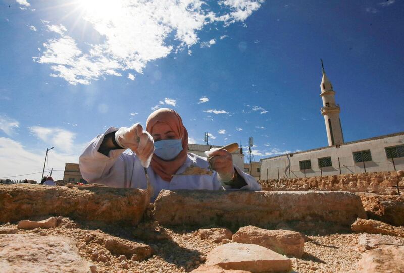 A worker restores a stone wall at the ancient church complex in Rihab, Jordan. AFP