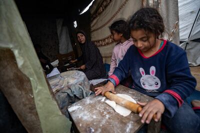 A Palestinian family makes bread in their tent in the Rafah camp for the displaced in the southern Gaza Strip. EPA
