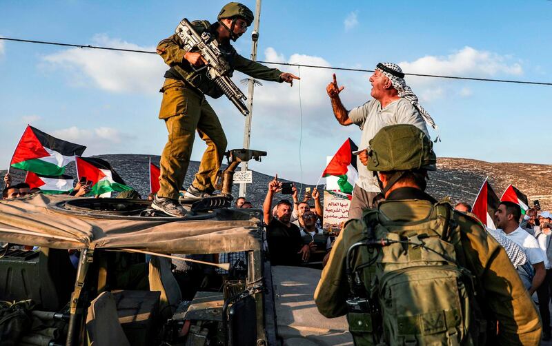 A Palestinian protester yells at an Israeli soldier as he confronts him atop an Israeli army vehicle during a protest against Israeli forces conducting an exercise in a residential area near the Palestinian village of Naqura, northwest of Nablus in the occupied West Bank.  AFP