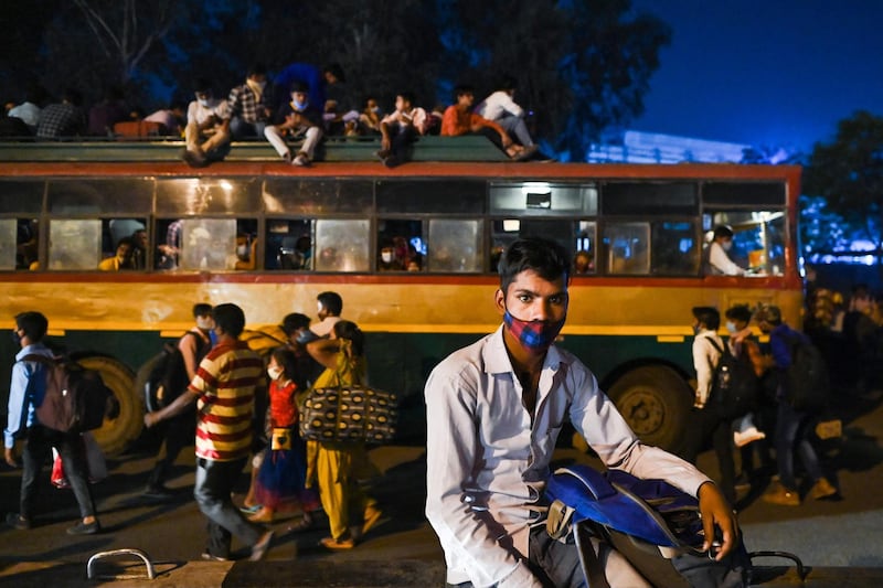 People crowd onto buses leaving New Delhi as the Indian capital goes into a week-long lockdown. AFP