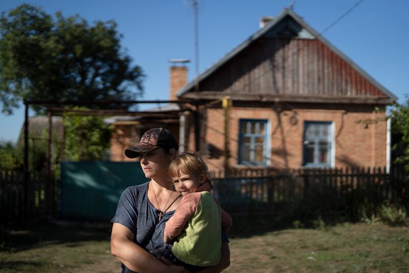 A woman and her daughter stand in front of their house in the village of Zorya, located about 20 kilometres from the nuclear power plant. AP