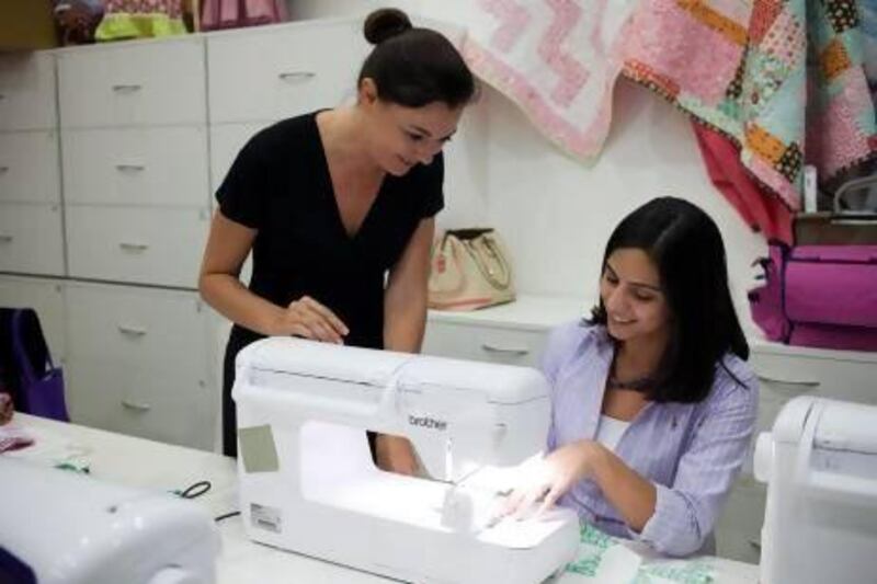 Rone Auret, left, an educator for Brother sewing machines, gives Maya Itani some tips at Craftland. Mrs Itani has set up a new website to raise awareness of the wide range of classes offered in the UAE. Razan Alzayani / The National