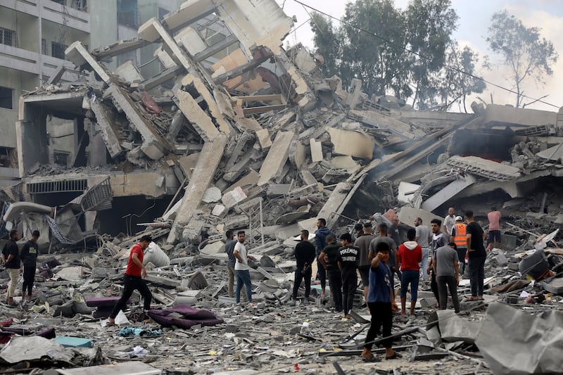 Palestinians inspect the damage of a destroyed building following Israeli air strikes on Gaza city. AP