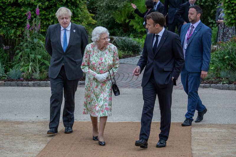 French President Emmanuel Macron and Queen Elizabeth chat as they arrive at a reception for the queen at The Eden Project in Cornwall, during the G7 Summit in June 2021. Getty Images