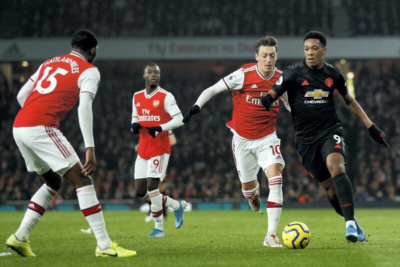 Manchester United's French striker Anthony Martial (R) vies with Arsenal's German midfielder Mesut Ozil (2nd R) ans Arsenal's English midfielder Ainsley Maitland-Niles (L) during the English Premier League football match between Arsenal and Manchester United at the Emirates Stadium in London on January 1, 2020. - Arsenal won the game 2-0. (Photo by Ian KINGTON / IKIMAGES / AFP) / RESTRICTED TO EDITORIAL USE. No use with unauthorized audio, video, data, fixture lists, club/league logos or 'live' services. Online in-match use limited to 45 images, no video emulation. No use in betting, games or single club/league/player publications.