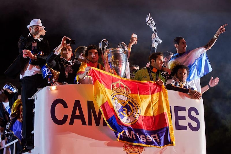 Real Madrid players Sergio Ramos, left, Cristiano Ronaldo, second left, Pepe, centre, Marcelo, second right, and Angel Di Maria, right, greet fans at Cibeles Square in Madrid following their Champions League final win on Saturday night. Gonzalo Arroyo Moreno / Getty Images / May 24, 2014