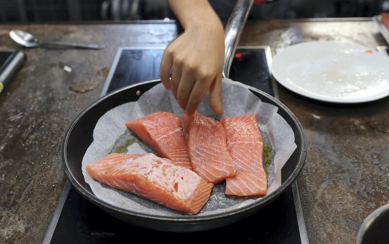 DUBAI, UNITED ARAB EMIRATES , March 5  – 2020 :-  Kids making salmon during the cooking class at the Top Chef Dubai cooking school on Jumeirah Beach Road in Dubai. (Pawan Singh / The National) For Lifestyle. Story by Janice Rodrigues