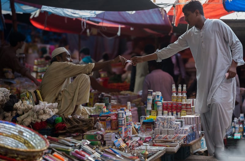 A vendor receives a payment from a customer at a local market in Karachi, Pakistan. Inflation in the South Asian country has accelerated to a 13-year high. Photo: Bloomberg