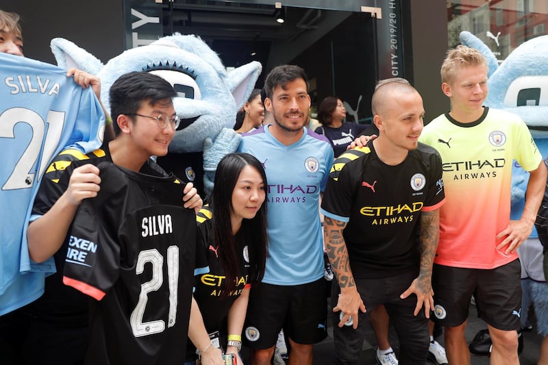 David Silva, Angelino and Oleksandr Zinchenko take pictures with fans during a promotional event in Hong Kong. Reuters