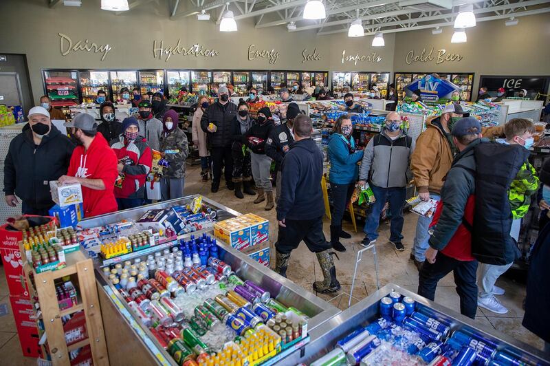 People queue to buy food at a petrol station in Pflugerville, Texas. Most homes in the area had been without electricity for nearly eight hours. Power companies performed rotating cuts to protect the grid. AP