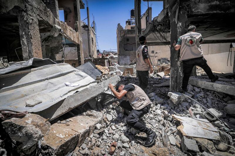 Explosives experts from Hamas search a destroyed building for unexploded projectiles. AFP
