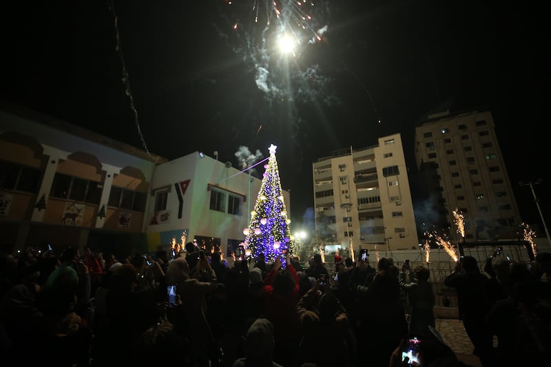 Gaza city residents attend the lighting of the Christmas tree, in an event organised by the YMCA Christian youth association.
