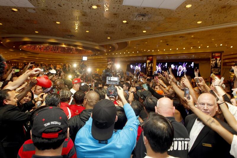 Manny Pacquiao is swarmed by a crowd and reporters and photographers last year while in Las Vegas for his fight against Timothy Bradley. Mike Young for The National / April 9, 2014