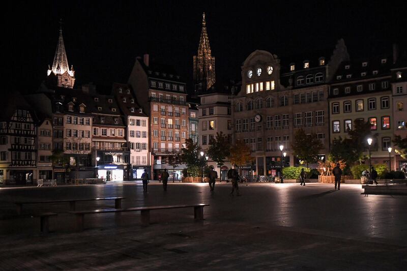 People walk on an almost empty Kleber square in Strasbourg, eastern France, on October 24, 2020, as a nighttime virus curfew enters into force as a measure against the spread of the Covid-19 pandemic caused by the novel coronavirus. (Photo by Patrick HERTZOG / AFP)