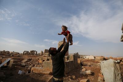 Mohamad Othman, 30, plays with his child at the archaeological site of Sarjableh in Idlib, Syria. All photos: Reuters
