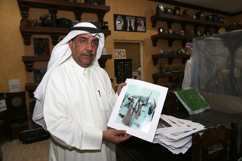 Jasim Al Ali holds the old picture of Sheikh Zayed he has as part of his expansive antiques collection at his home in Sharjah. Pawan Singh / The National 