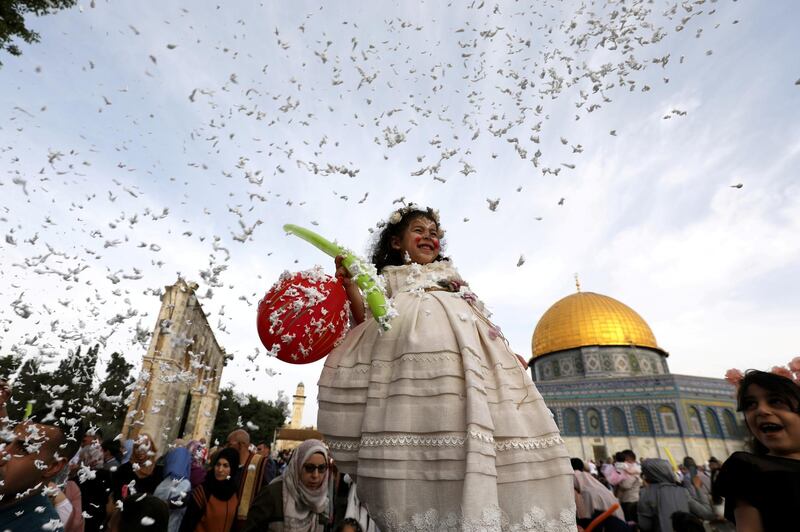 Foam is sprayed as a girl smiles during celebrations after Palestinians performed Eid al-Fitr prayers. Reuters