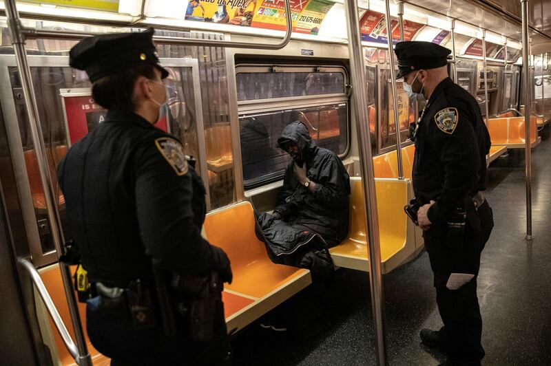 New York City Police officers wake up a passenger on the subway. Reuters
