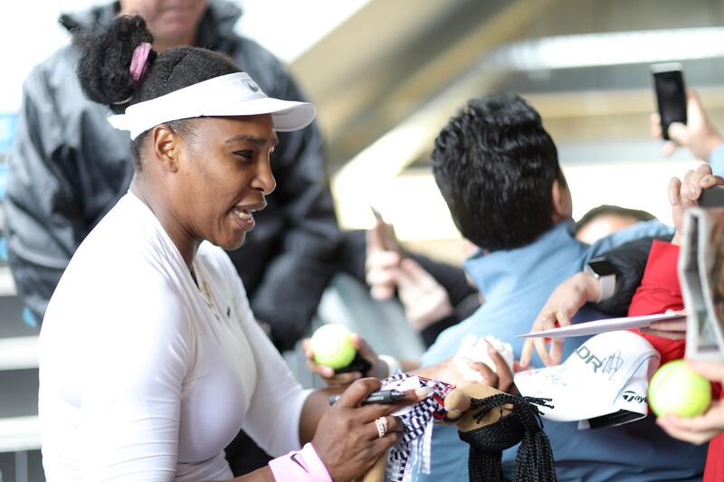 Serena Williams signs a Maori doll after her first round win against Camila Giorgi. Getty Images