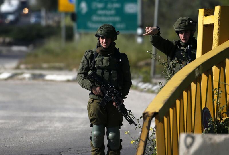 Israeli soldiers check the site where a Palestinian man was killed after he reported tried to stab an Israeli driver at a junction south of Nablus in the occupied West Bank on April 3, 2019. / AFP / JAAFAR ASHTIYEH
