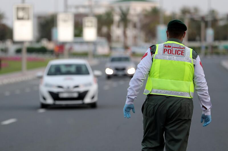 DUBAI, UNITED ARAB EMIRATES , April 16– 2020 :- Dubai Police officer stopping the private vehicles and checking the movement permit near Madinat Jumeirah in Dubai. Dubai is conducting 24 hours sterilisation programme across all areas and communities in the Emirate and told residents to stay at home. UAE government told residents to wear face mask and gloves all the times outside the home whether they are showing symptoms of Covid-19 or not.  (Pawan Singh / The National) For News/Online/Instagram