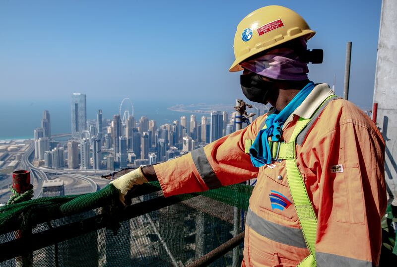 A construction worker takes in the view of Dubai from the tower.