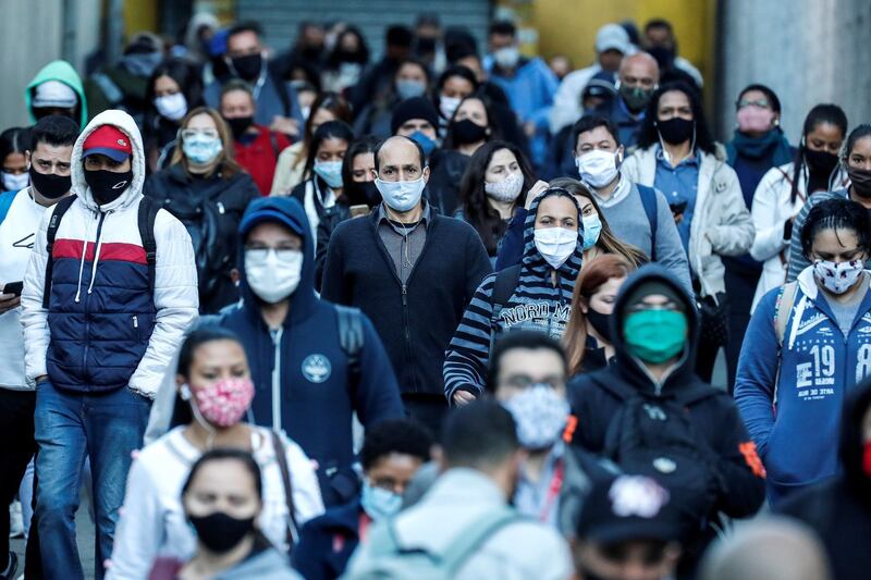 People protected with face masks walk in the southern area of Sao Paulo, Brazil. EPA