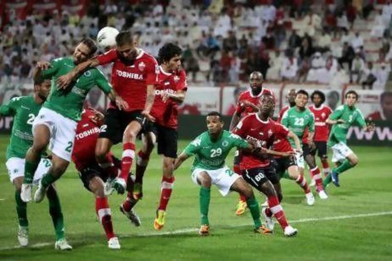 Al Ahli, in red, defend a ball into their penalty area as Al Shabab go on the attack in Dubai last night.