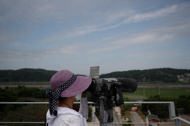 A visitor wearing a face mask uses binoculars to view from the Imjingak Pavilion in Paju, South Korea, Sunday, June 14, 2020. AP